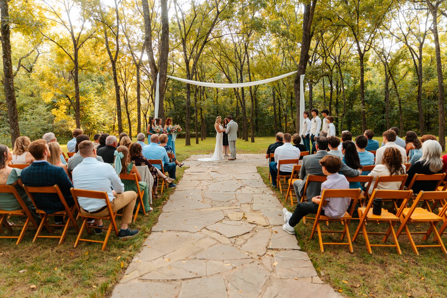 Wooden chairs set up for an outdoor wedding ceremony surrounded by autumn trees with golden leaves. wedding photography st louis
