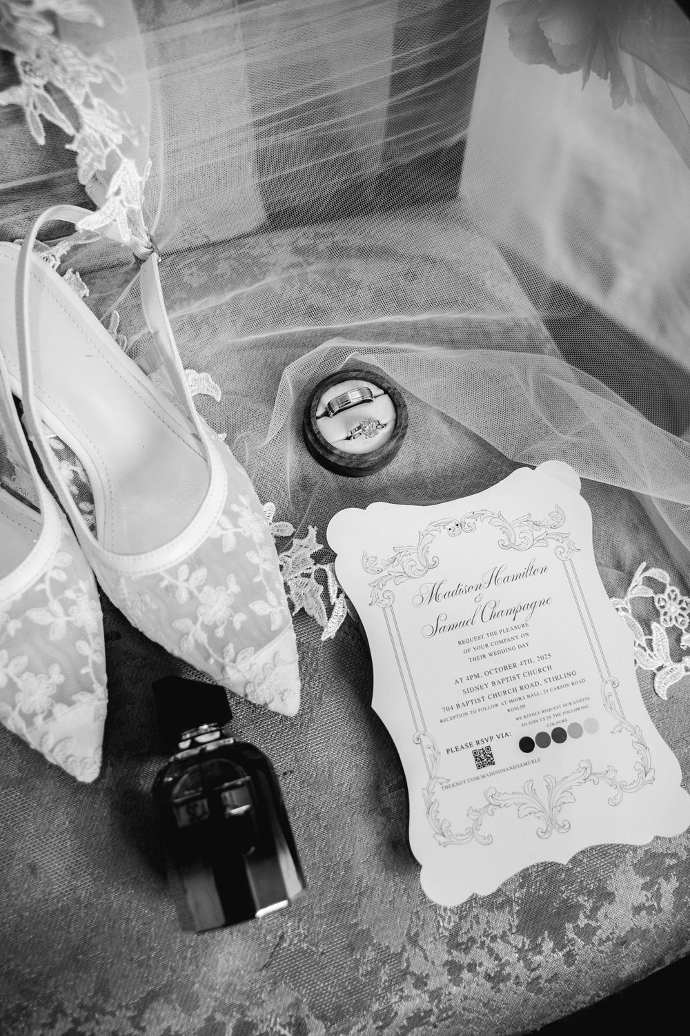 Black and white wedding invitation details with delicate lace and paper elements arranged artistically.