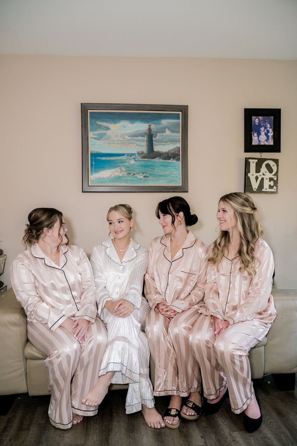 Group in matching silk robes sitting together on floor against wall with framed coastal artwork.