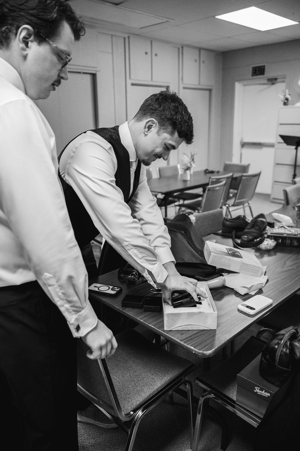 Chefs in white coats work at prep stations in a commercial kitchen preparing ingredients and dishes.