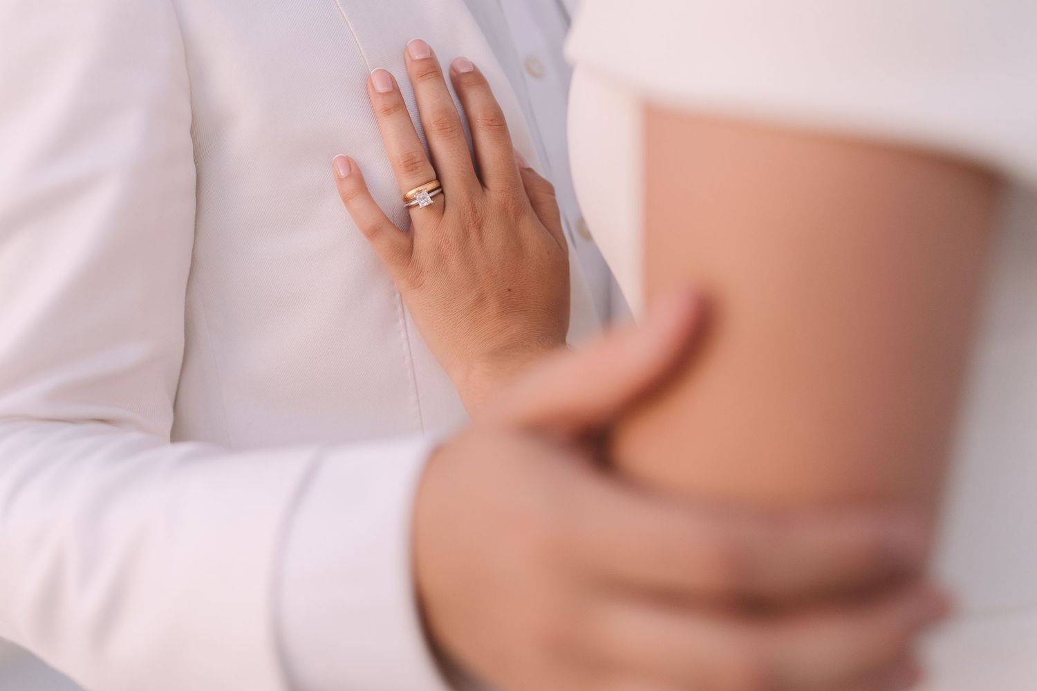 Close up view of destination wedding couple embrace at their Santorini wedding at sunset.