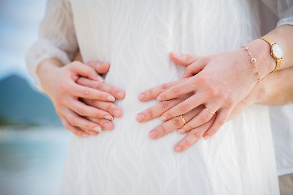 Close up detail shots of hands with wedding rings on a sunny day. Shot by Luminair Studio