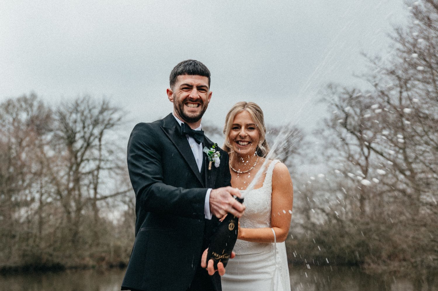 A couple shares a joyful moment together outdoors on their wedding day in winter.