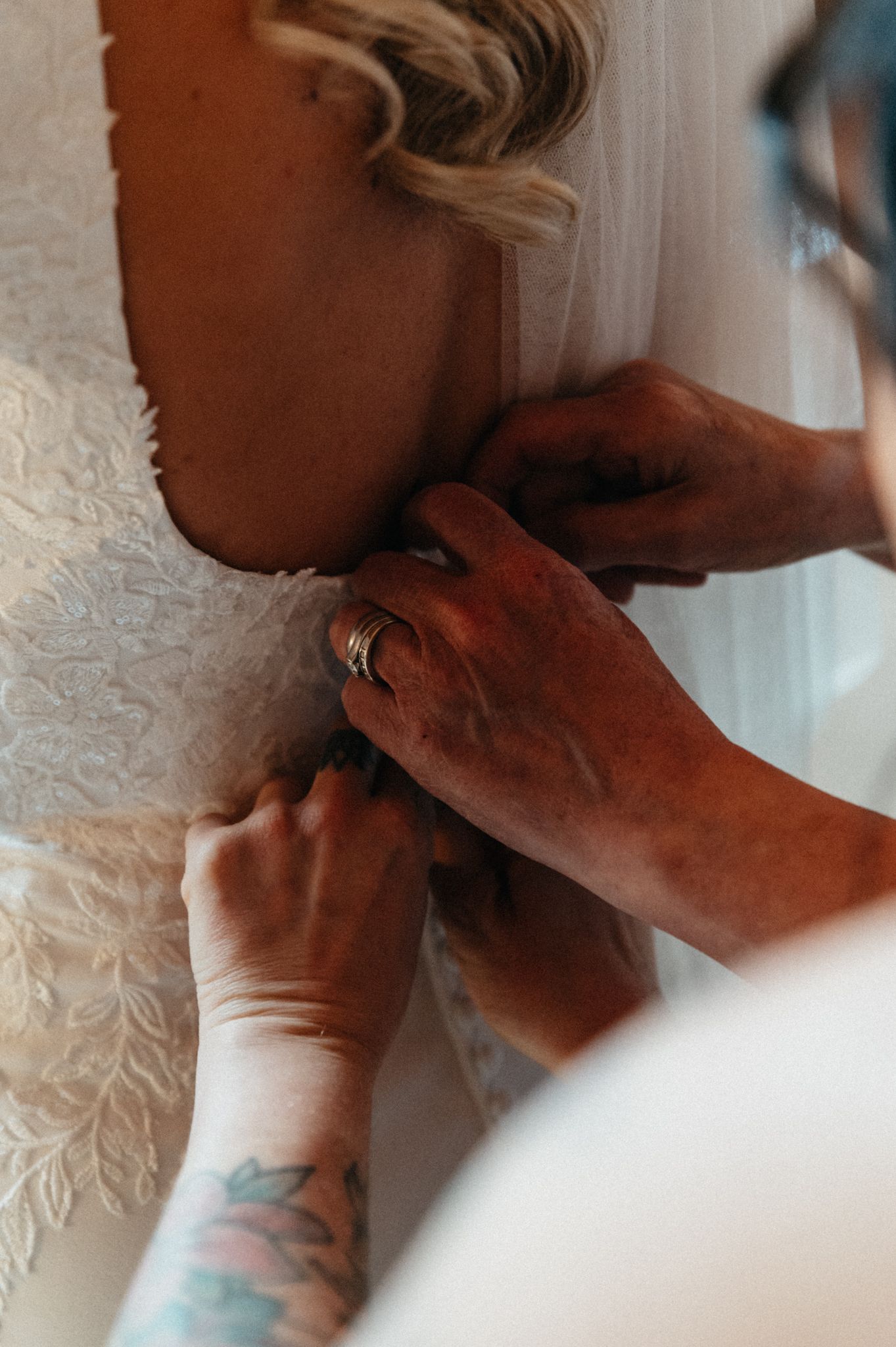 Close-up sequence showing details of a white lace wedding dress being fastened.