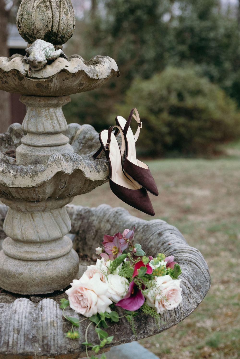 A series of decorative stone garden pillars adorned with fresh pink and purple floral arrangements.