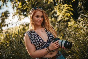 Photographer with professional camera equipment working in an outdoor natural setting.