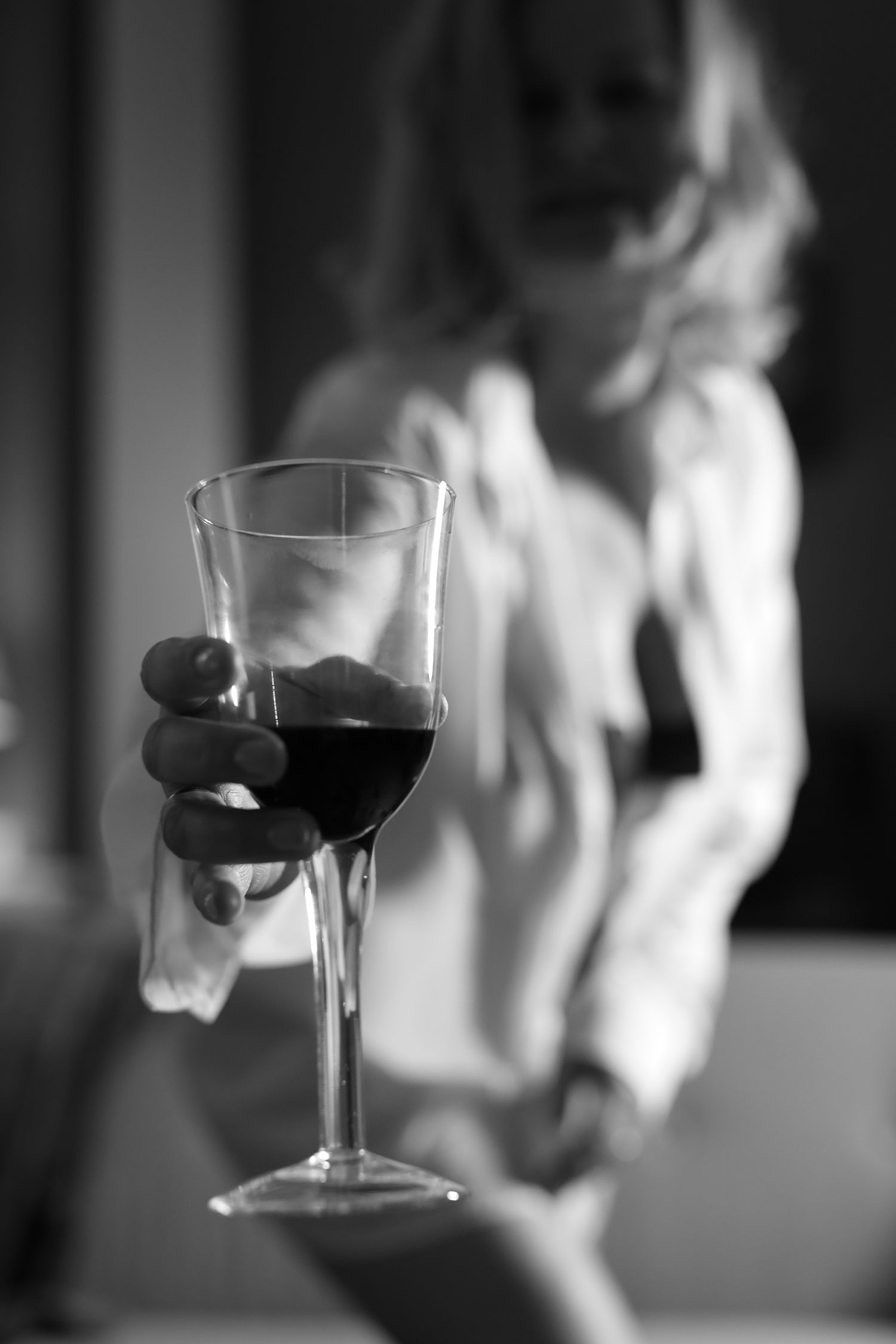 Black and white image of wine glasses in a sequence showing red wine being swirled and spilled.