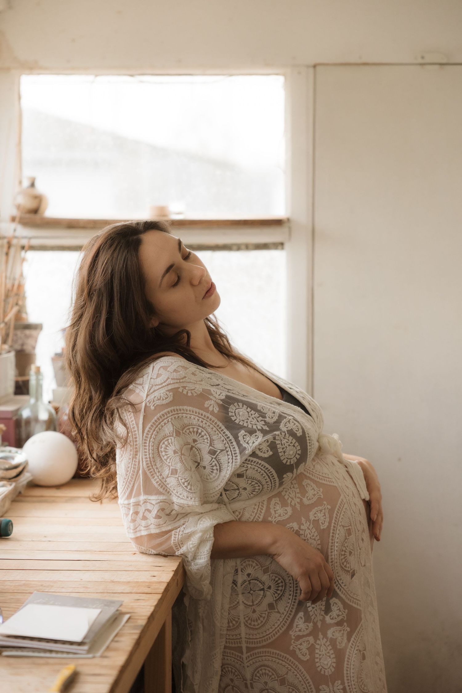 A series of artistic photos showing a person in a lace dress moving expressively against a light-filled interior space.
