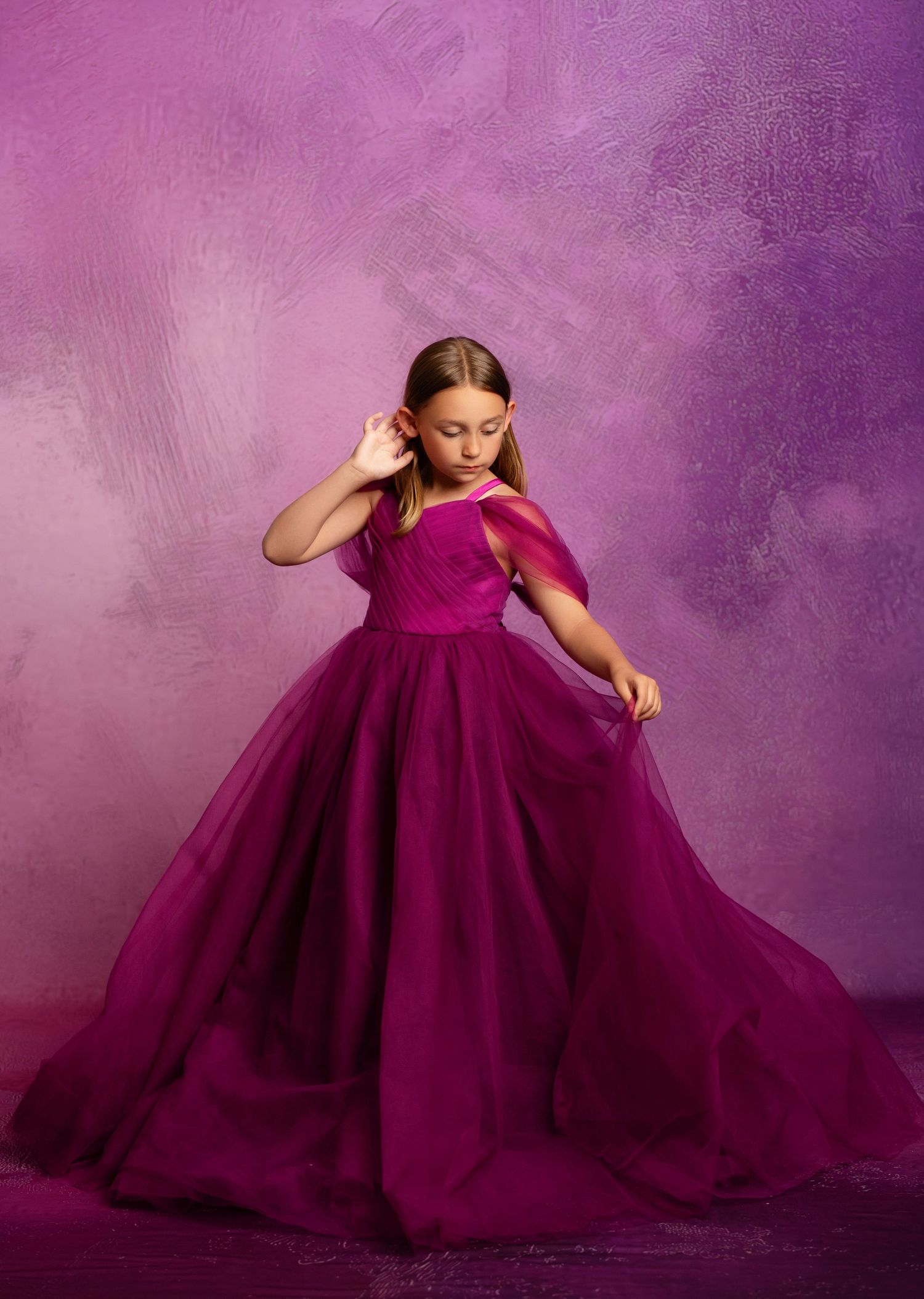 A bright red dress with puff sleeves and heart balloon photographed against a red studio backdrop.