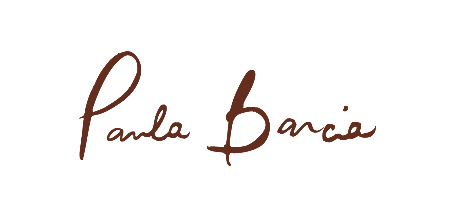 A signature written in brown ink on white paper shows elegant cursive handwriting with flourishes.