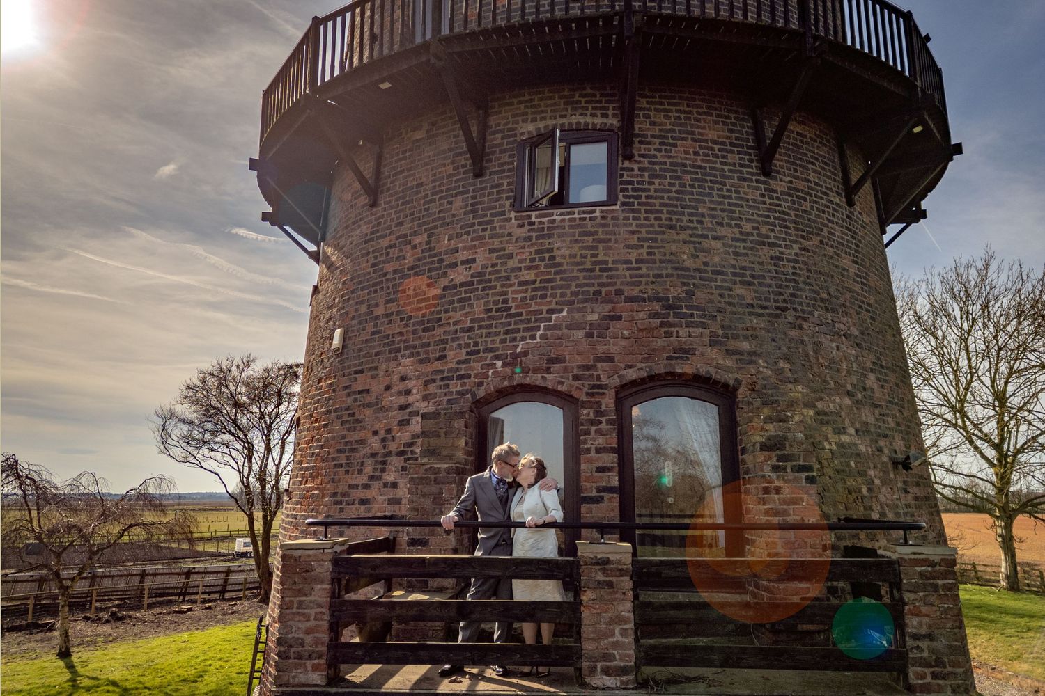 Dorothy and John sharing a quiet moment on the balcony of the windmill at Windmill Farm in Burscough during their wedding day.