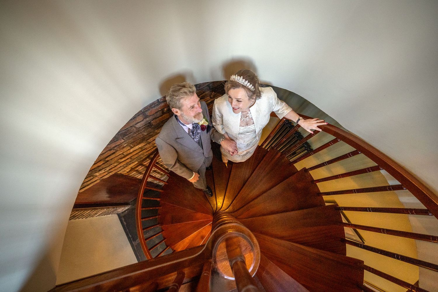 Dorothy and John holding hands on the curved staircase inside the windmill tower at Windmill Farm in Burscough.