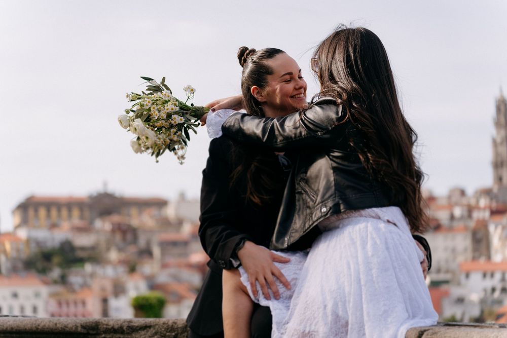 A couple embraces during their romantic wedding photoshoot in a scenic Mediterranean coastal town setting.