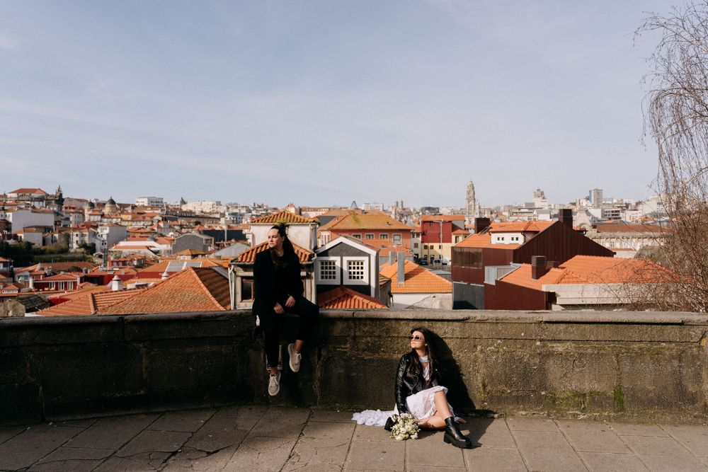 Panoramic view of traditional orange-roofed buildings and architecture in Porto, Portugal against a cloudy sky.
