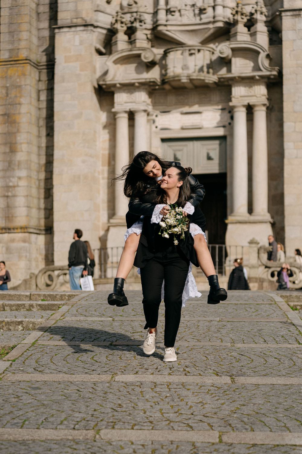 A couple sharing intimate moments in front of an ornate stone cathedral entrance.