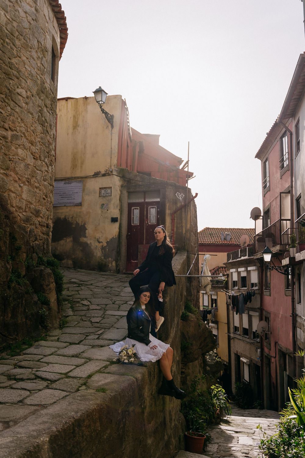 Narrow cobblestone street with old stone buildings and pink facades in a historic neighborhood.
