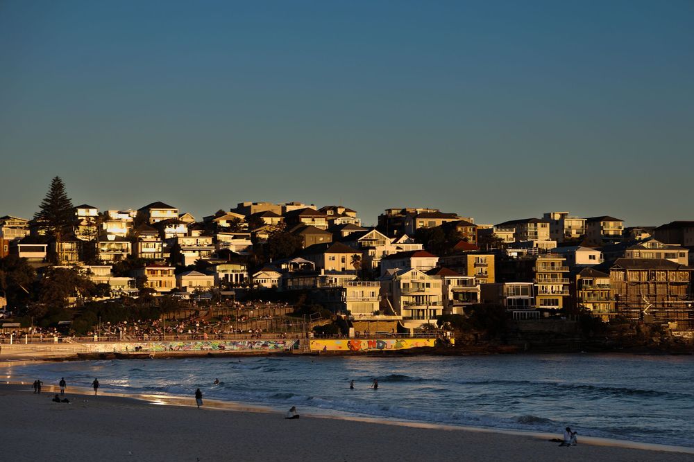 The sun setting creating a golden glow on the buildings at Bondi Beach