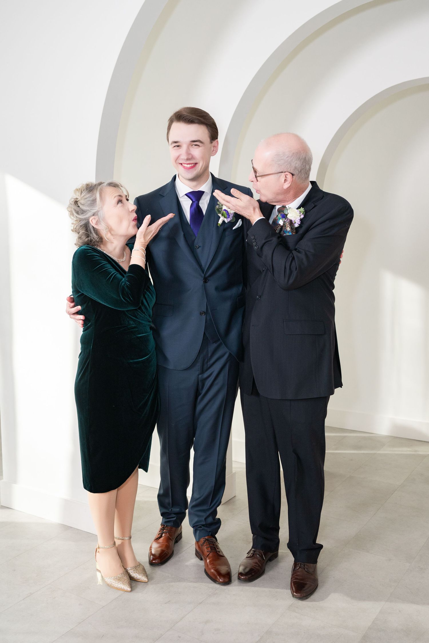 A couple shares an intimate moment on a staircase with a curved wooden architectural detail.