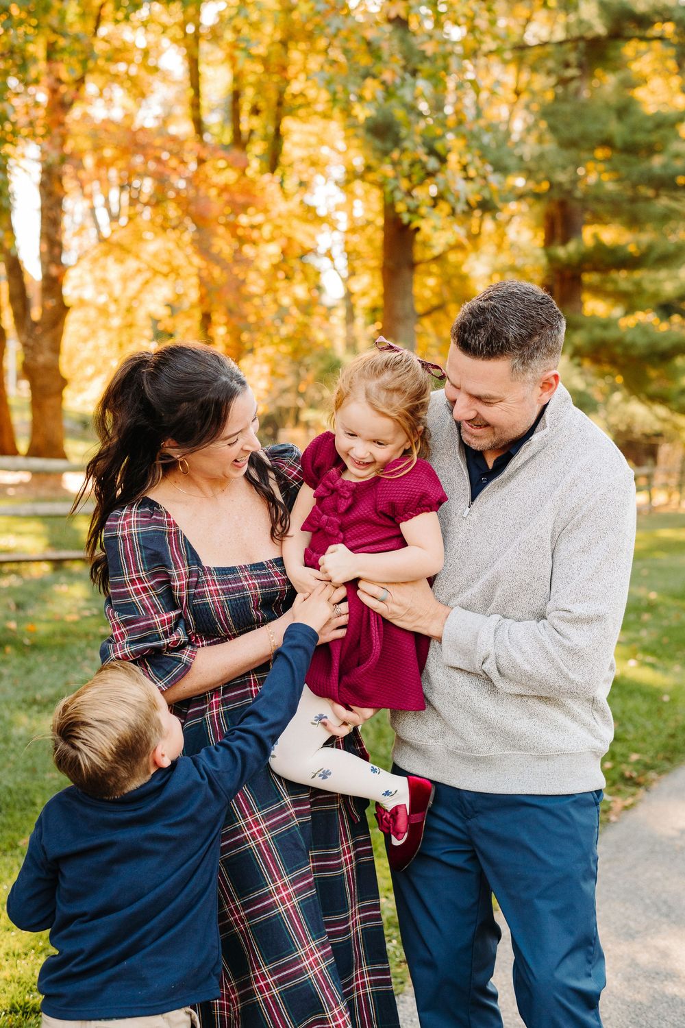 Candid family moments captured in a series of playful interactions during fall photoshoot.