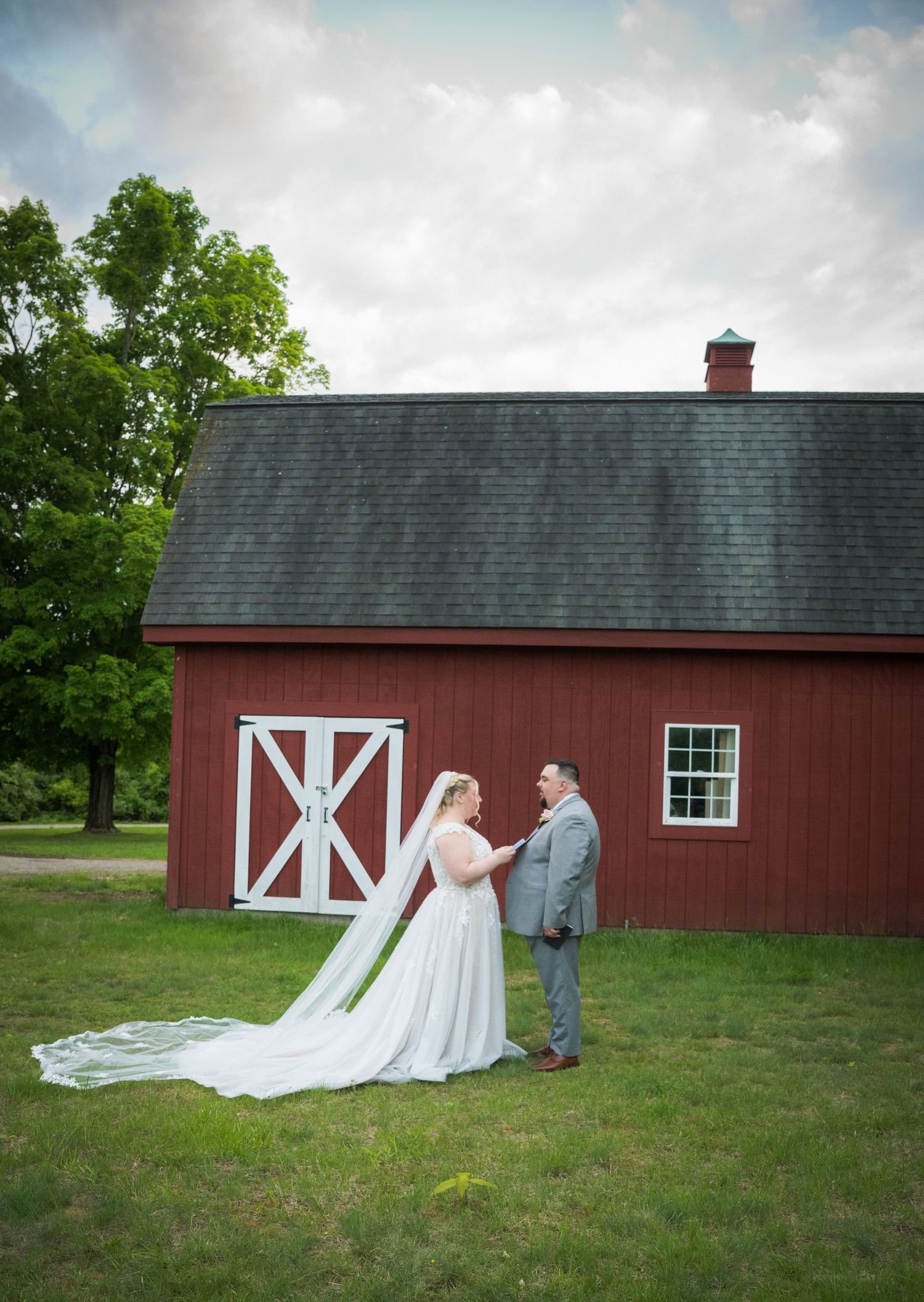 A sequence of photos showing a couple in formal attire posing beside a rustic red barn in a grassy field.
