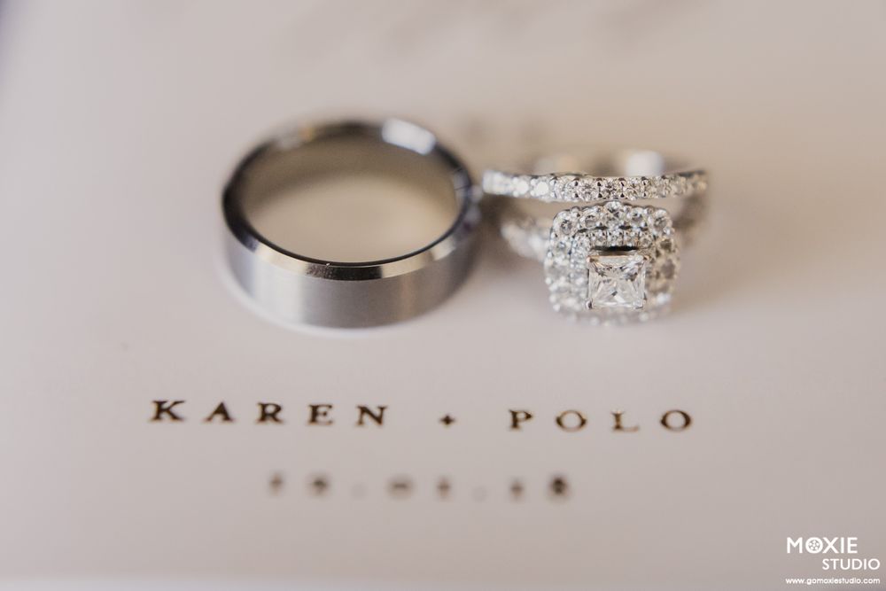 Wedding rings and names Karen and Polo with date displayed on elegant white paper with delicate typography.