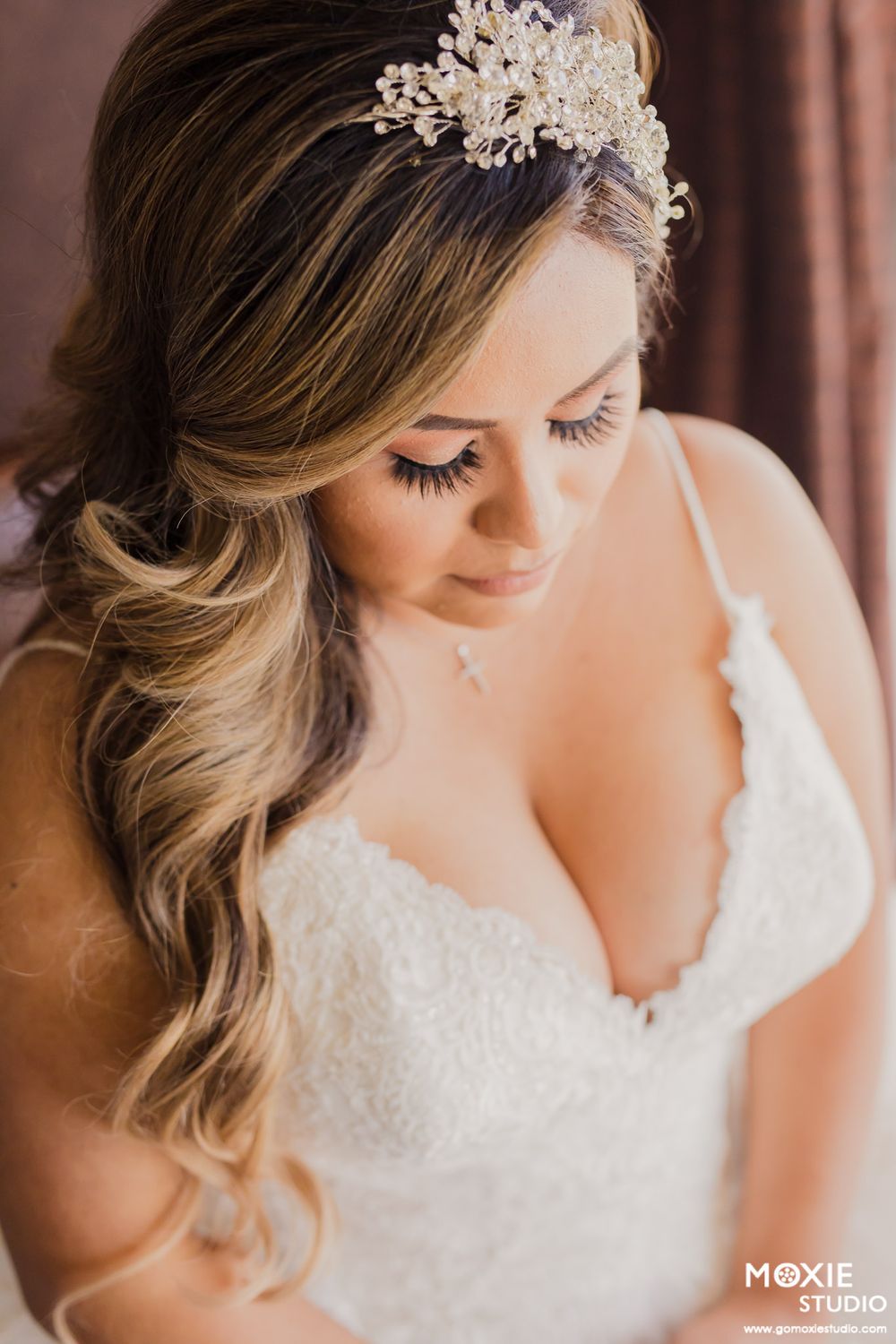 Delicate lace bridal headpiece and soft waves hairstyle details in romantic lighting.