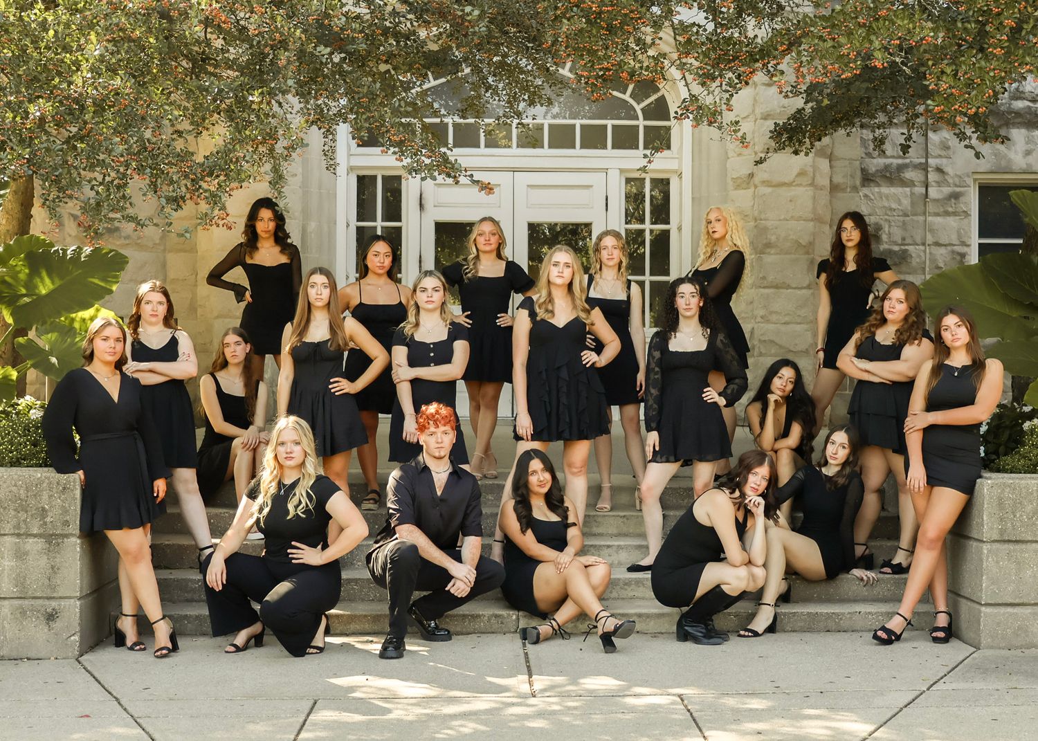 Casual group portraits of people in black outfits sitting and standing on outdoor steps.