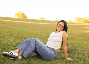 Relaxed outdoor poses in jeans and striped top during golden hour.