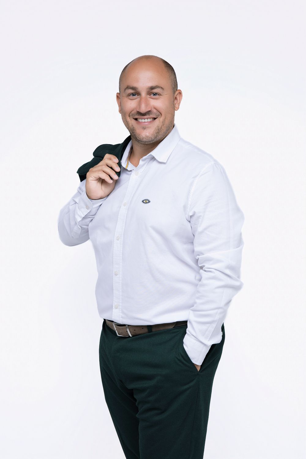 Professional portrait of someone in a crisp white button-down shirt and dark pants against a white background.