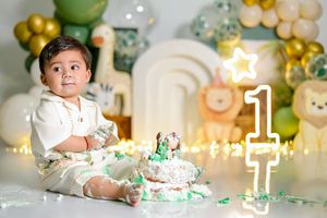 A festive green and gold party setup with balloons and decorative elements creates an elegant celebration atmosphere.