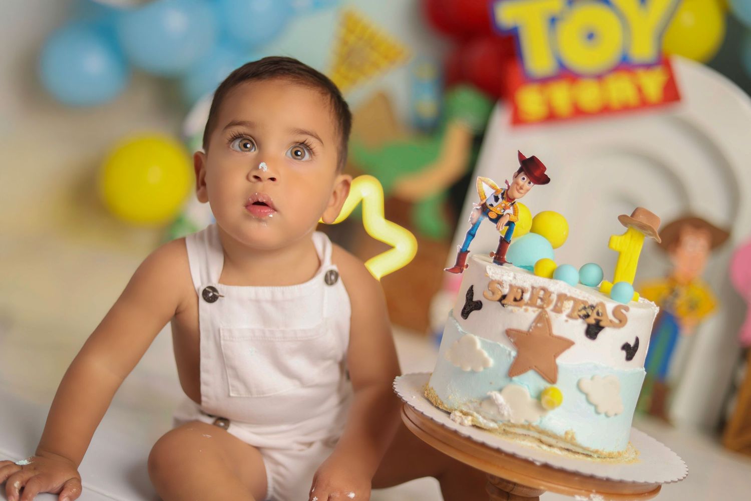 A Toy Story themed birthday celebration with a decorated cake and colorful balloons in the background.