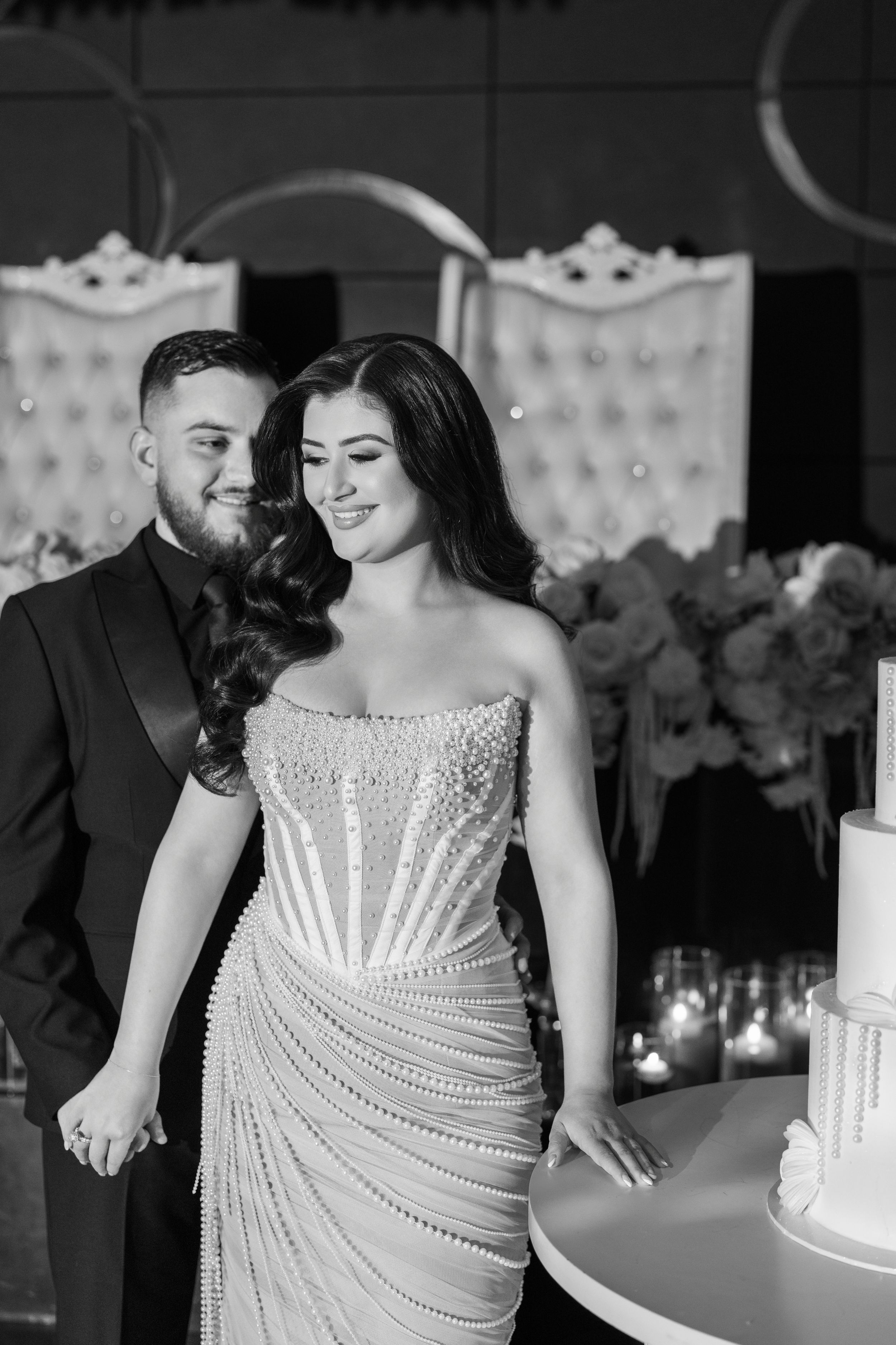 A romantic black and white wedding photo series showing intimate moments between a couple with a beaded white dress.