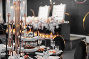 Elegant table settings with rose gold decor and white linens at an upscale wedding reception.