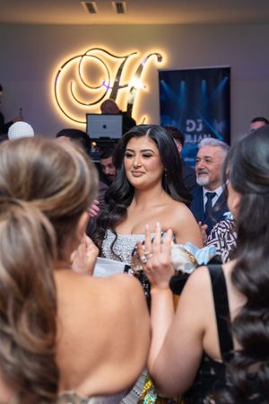A lively crowd of wedding guests dancing and celebrating together at an indoor reception party.