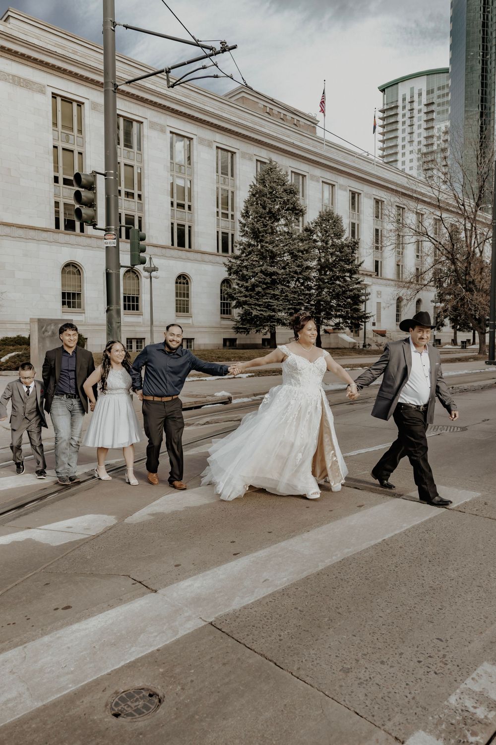 Bride and Groom walking across a street with family behind them