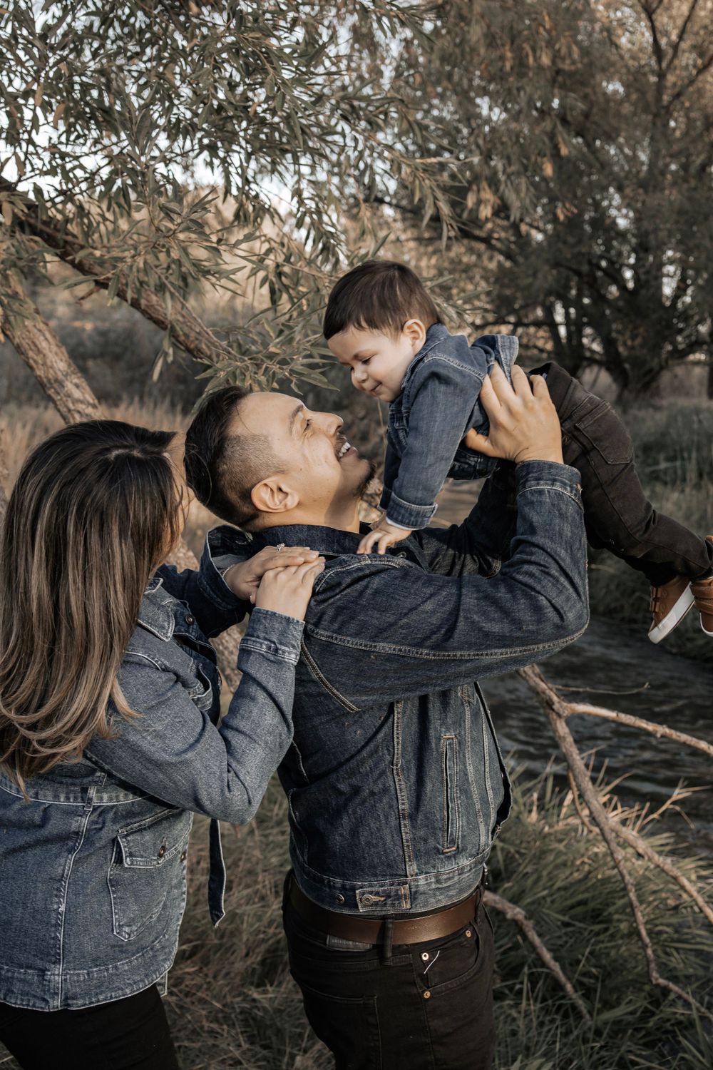 Mom and Dad playing with toddler child and smiling