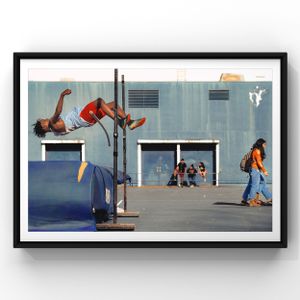 Athletic figure performs dramatic back arch over high jump bar in outdoor schoolyard setting while others play nearby.