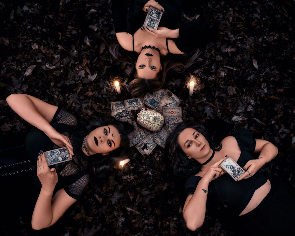 Artistic dark photography series showing people lying on ground with dramatic lighting and candles.