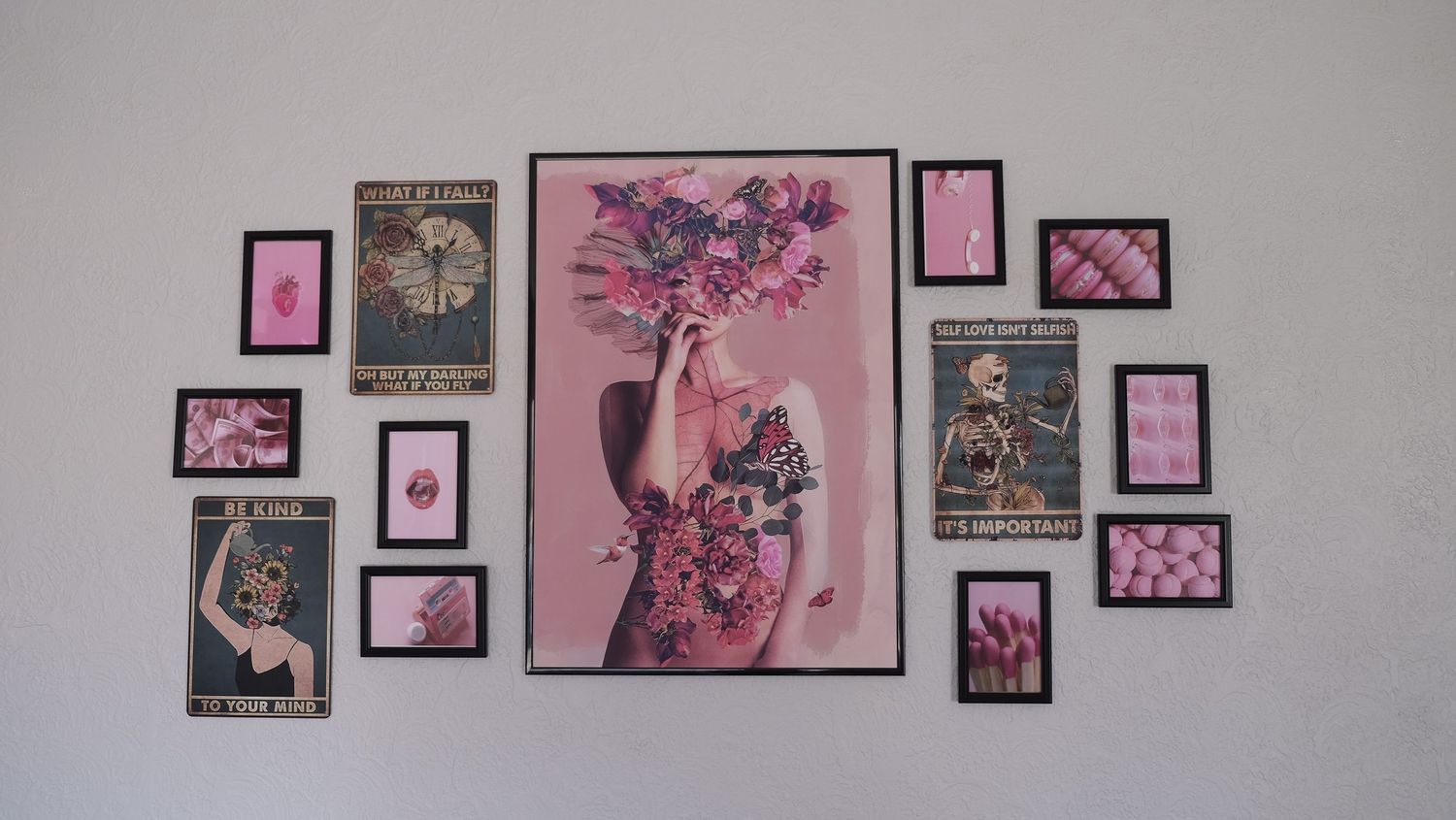 Pink and black themed wall art gallery featuring vintage-style prints arranged around a central floral vase artwork.