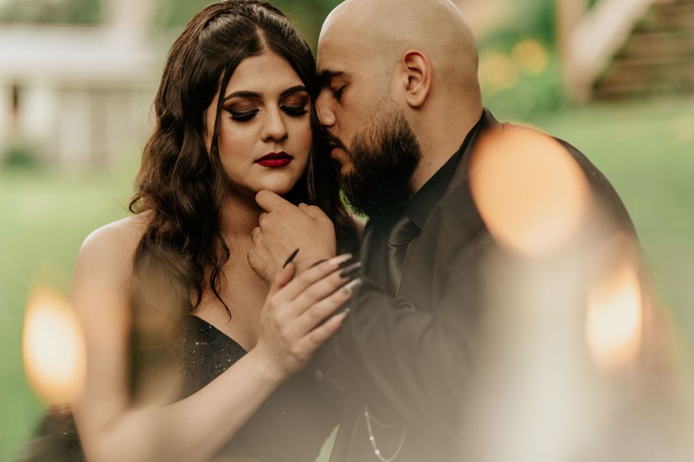 Romantic couple sharing an intimate moment in outdoor setting with soft bokeh lighting effects in foreground.
