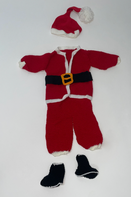 Small red and white Santa Claus outfit with black boots displayed on white background.
