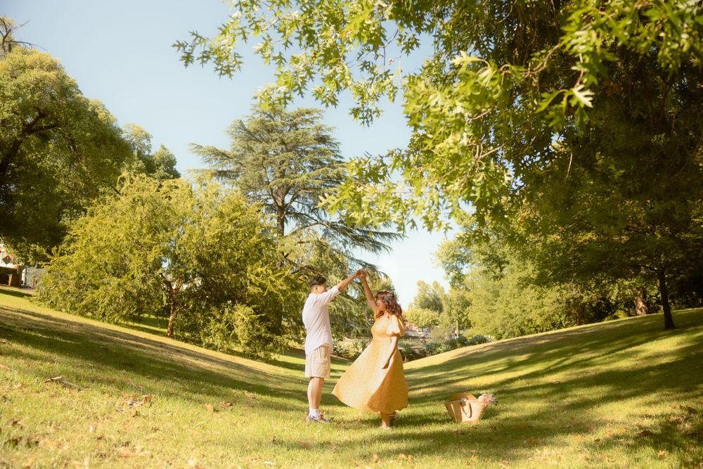 Couple enjoying a sunny day in a grassy park with their dog.