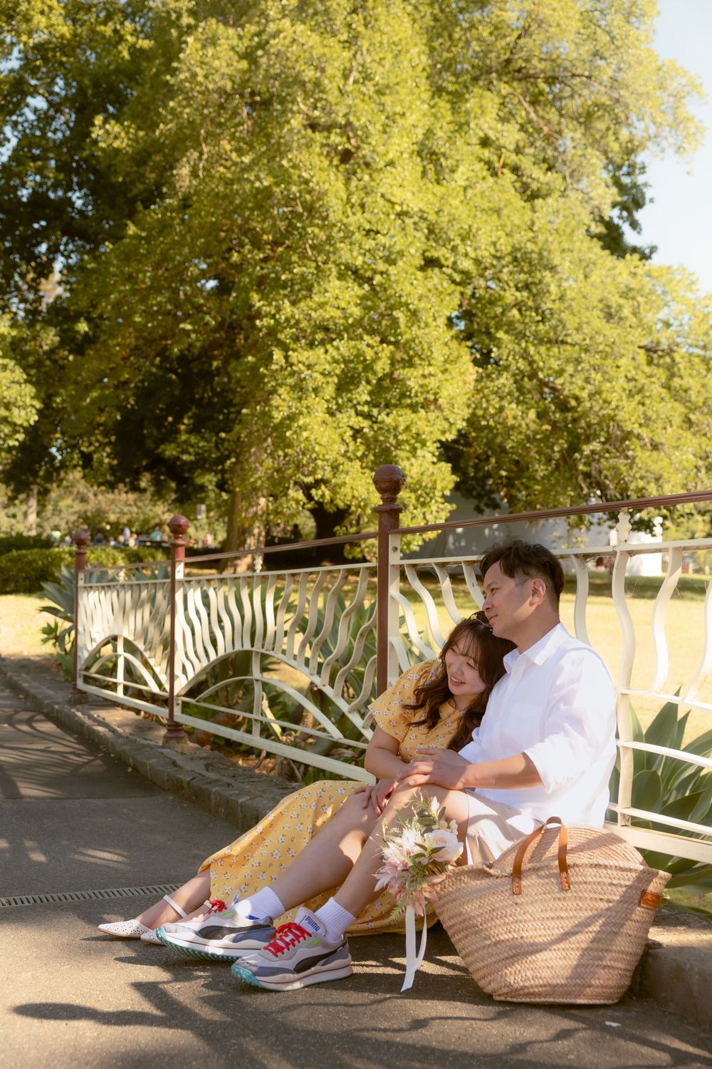 Couple resting on a park bench with a picnic basket on a sunny afternoon.
