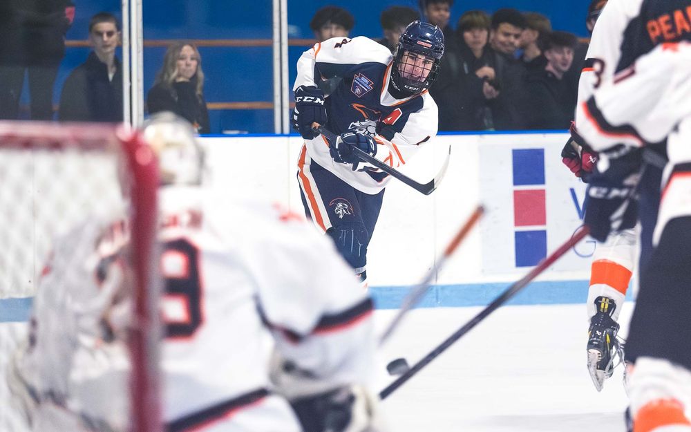 Trojans player lines up a shot with the opposing goalie and defenders ready by SportsFox Photography, Hershey PA.