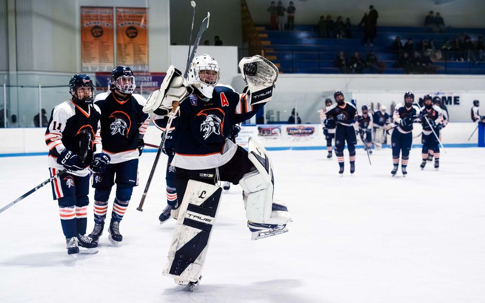 Trojans hockey team celebrates on the ice after clinching the semifinal win by SportsFox Photography, Hershey PA.