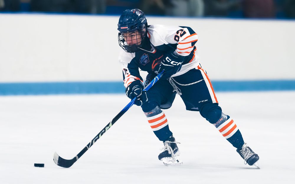Trojans player skates with the puck, focused on the play during the semifinal by SportsFox Photography, Hershey PA.