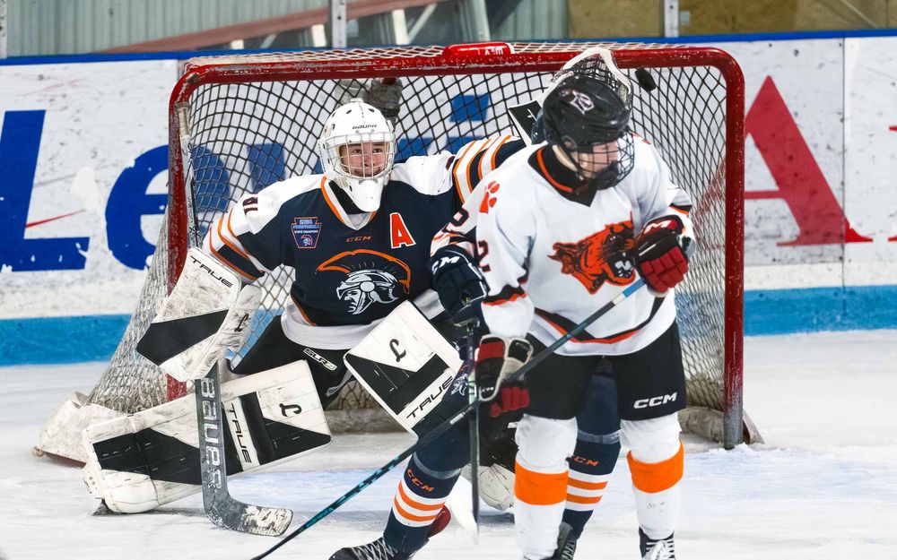 Trojans goalie makes a save as defenders clear the puck near the crease by SportsFox Photography, Hershey PA.