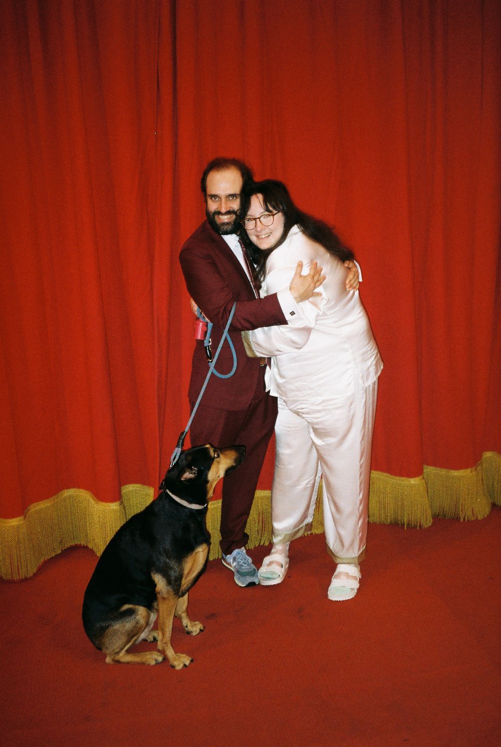 Couple hugs with their dog at wedding nuptials at Bob Baker theater