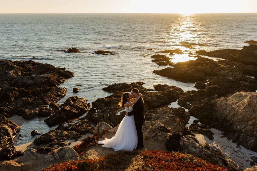 Sunset wedding photography session on rocky coastal cliffs with dramatic ocean views.