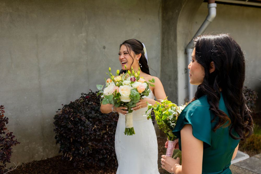 Wedding party in emerald green dresses and formal attire posing together.